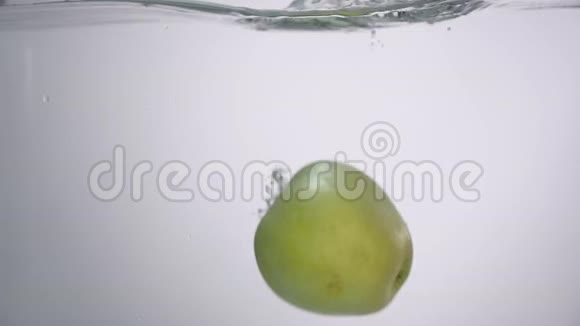一滴滴的水从新鲜的绿苹果掉进水里有小的圆形波浪和小的飞溅视频的预览图