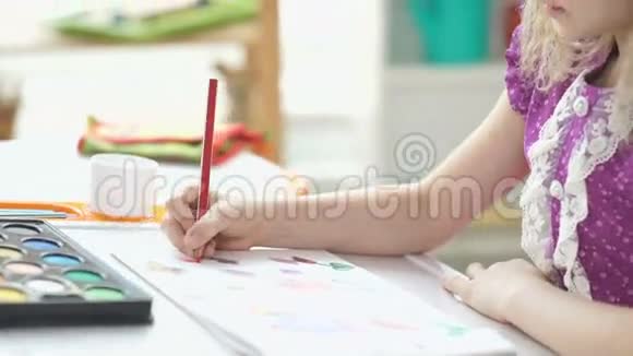 绘画八岁的女孩坐在书桌前画画视频的预览图