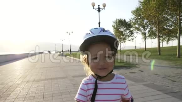 夏季公园里戴着头盔穿着溜冰鞋的小女孩视频的预览图