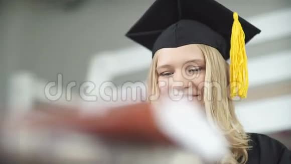 戴着硕士帽和长袍的毕业生持有文凭的毕业生视频的预览图