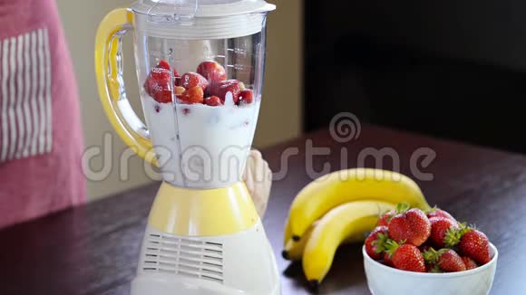 女人用搅拌机做草莓奶昔视频的预览图