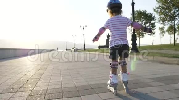 夏季公园里戴着头盔穿着溜冰鞋的小女孩视频的预览图