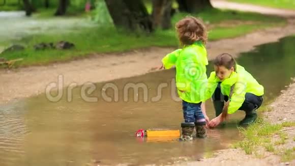 孩子们在雨后的大水坑里玩耍视频的预览图