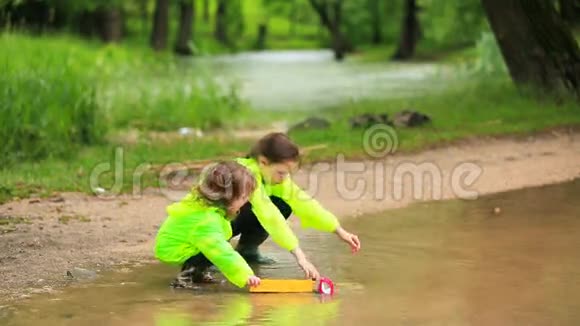 可爱的孩子们在公园的大水坑里玩汽车视频的预览图