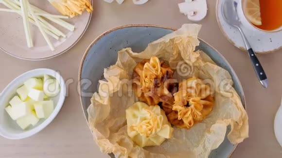 朱莉安用面团在面包纸上的盘子里烤上面有茶和黄油特写镜头视频的预览图