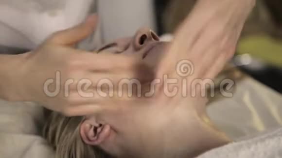 做面部按摩的美女在美容水疗中心用油进行手指按摩视频的预览图