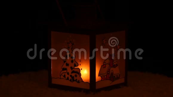 在黑暗中点燃蜡烛的圣诞灯笼在花环的背景上视频的预览图