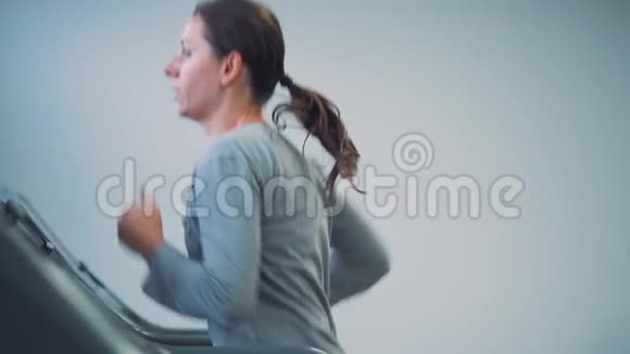 在健身房跑步机上跑步的女人慢动作视频的预览图