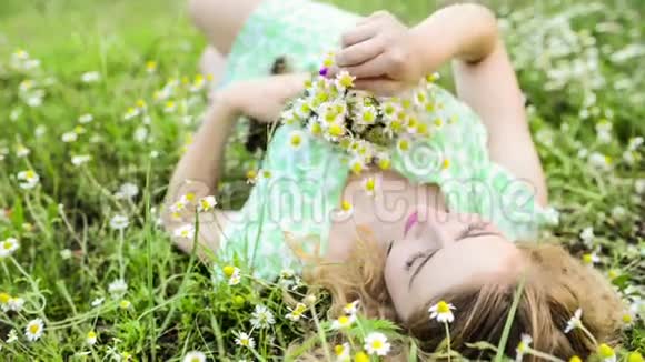 女孩依靠大自然美丽的女孩躺在田野上视频的预览图