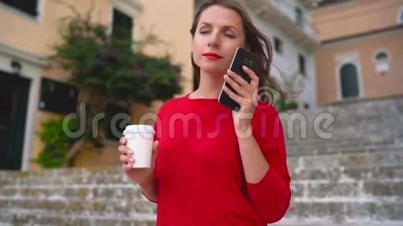 忙碌的女人站在户外的楼梯上用智能手机说话视频的预览图