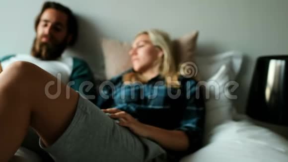 夫妻在家睡觉时使用手机互动视频的预览图