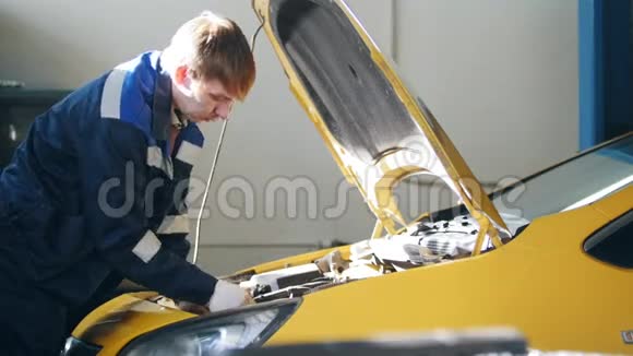 机械师在汽车的敞篷中工作发动机电池喷油器汽车服务视频的预览图