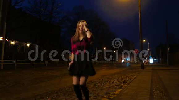 一个可爱的微笑少女在夜城街的肖像笑着玩着视频的预览图