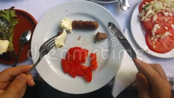 在餐馆里吃香肠和奶酪和新鲜西红柿的男人视频的预览图