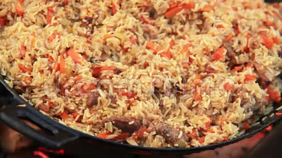 从大米肉类和蔬菜中提取的五颜六色的中东菜肴正在明火上准备视频的预览图