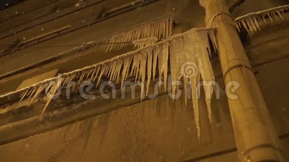 危险的冰柱挂在屋顶上视频的预览图