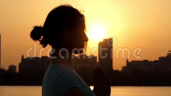 这个姿势在日落时很美女孩练习瑜伽视频的预览图