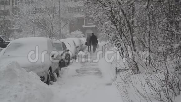 房子附近的人行道上有一排积雪覆盖的汽车莫斯科俄罗斯视频的预览图