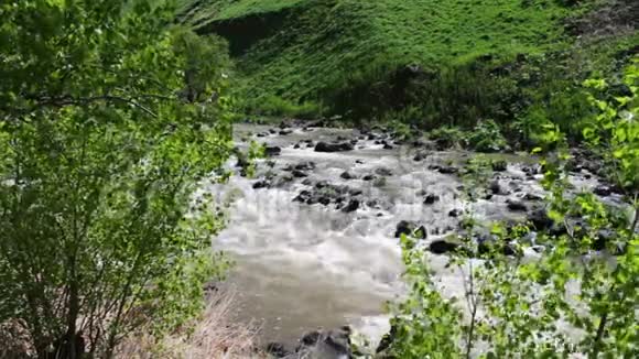 连绵起伏的山景中山涧流水潺潺山石奔腾视频的预览图