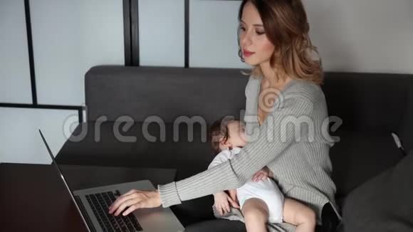母亲带着孩子试着用笔记本电脑工作视频的预览图