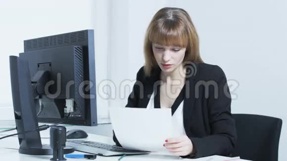 一个年轻漂亮的女人在看文件的时候视频的预览图