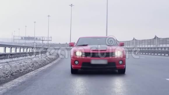 红色肌肉汽车向高速公路摄像头行驶视频的预览图