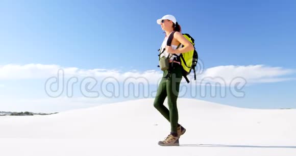 背着背包在沙漠中行走的女人视频的预览图