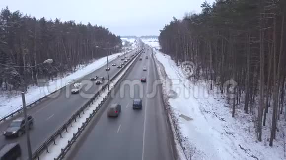 在雪地森林的冬季公路上行驶的无人观景车视频的预览图