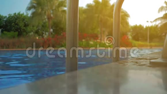 一个漂亮的女孩走进游泳池夏日的阳光慢动作视频的预览图