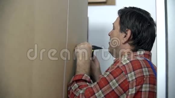 男人把钉子钉进衣柜的后面视频的预览图