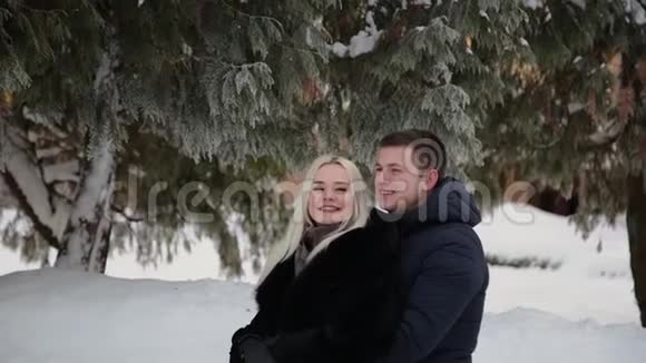 美丽的年轻夫妇拥抱和交谈在一个城市冬季公园视频的预览图