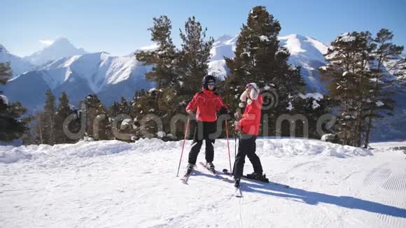 在滑雪场的家庭度假两个滑雪者在山上视频的预览图