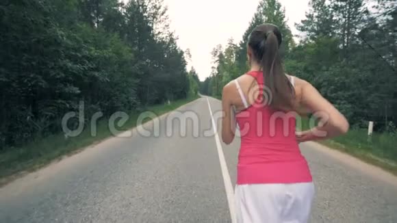 在森林里奔跑的年轻女子健康苗条的年轻女运动员跑步视频的预览图