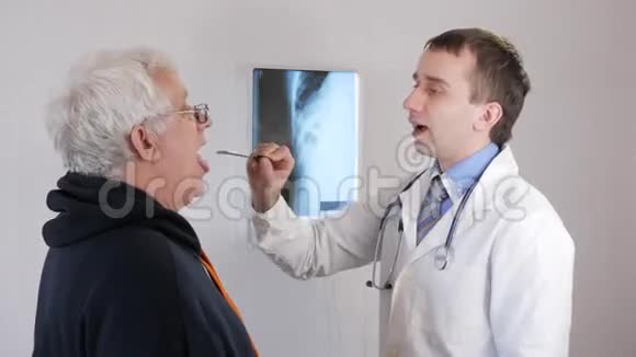 一位年轻的男医生检查一位老人的喉咙人说诊断规定治疗视频的预览图
