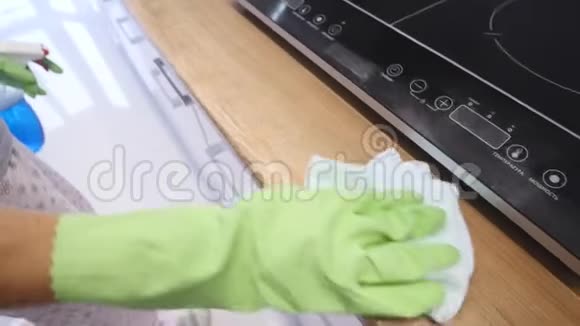 女人用绿色手套打扫厨房视频的预览图
