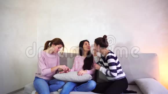 可爱的女朋友在约会时收集女朋友帮助看起来漂亮晚上坐在明亮的房间里的沙发上视频的预览图