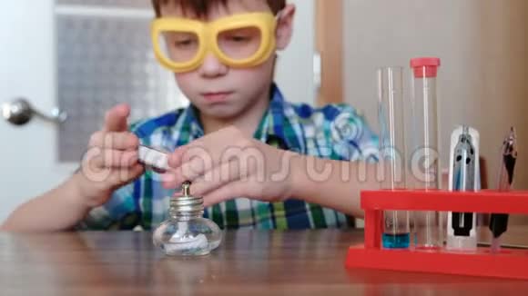 家庭化学实验男孩用火柴点燃燃烧的酒精灯视频的预览图