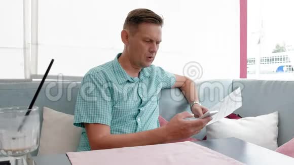 成熟男人在咖啡馆里浏览文件视频的预览图