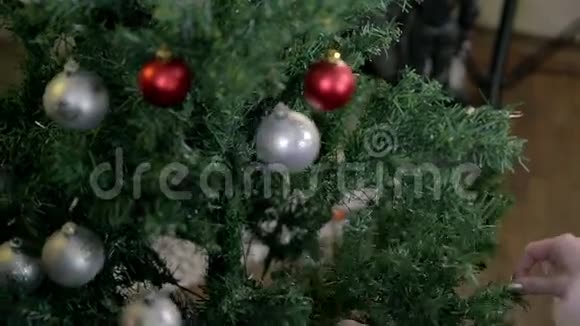 在树上挂满圣诞装饰品的女性身上视频的预览图