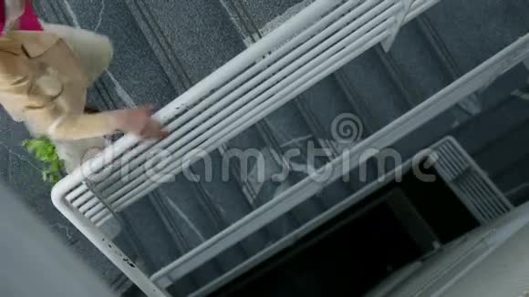 女人扶着栅栏走上楼梯视频的预览图