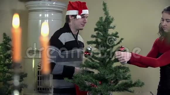 在装饰圣诞树的时候给女孩戴上圣诞帽视频的预览图