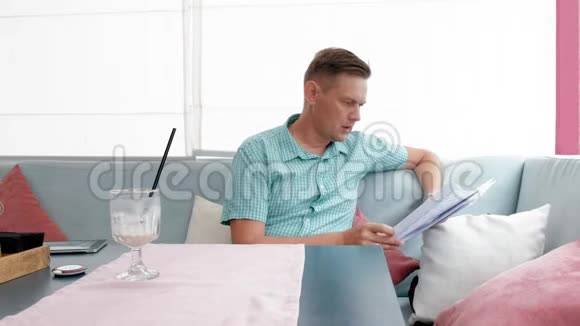 成熟男人在咖啡馆里浏览文件视频的预览图