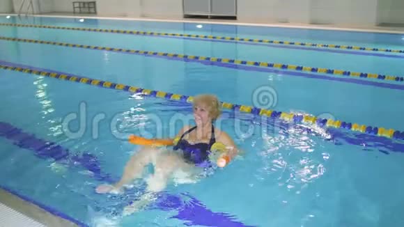 老妇人在游泳池里用面条做运动视频的预览图