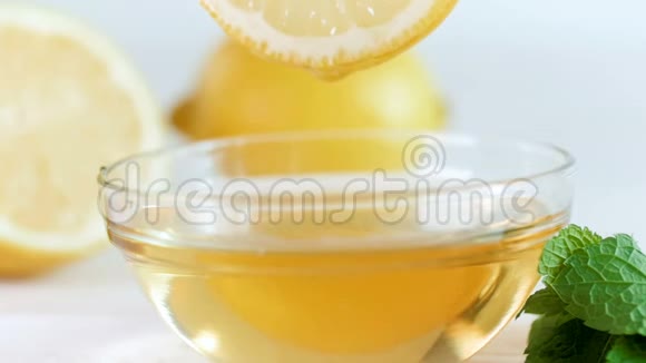 在玻璃罐中从柠檬片中慢慢滴下蜂蜜的慢镜头视频的预览图