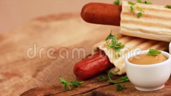 两只美味的法式烤热狗配芥末和番茄酱在老式砧板上视频的预览图
