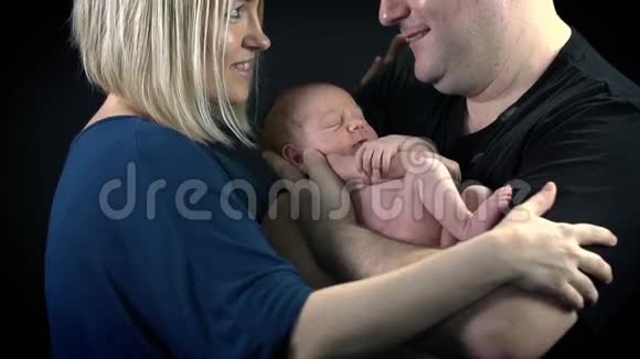 父母看着对方的眼睛婴儿在他们中间视频的预览图