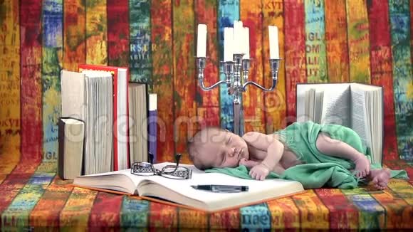 一个带着一堆书的彩色摄影装置上的小宝宝视频的预览图