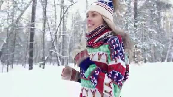 冬天在森林里奔跑的快乐年轻女子的肖像视频的预览图