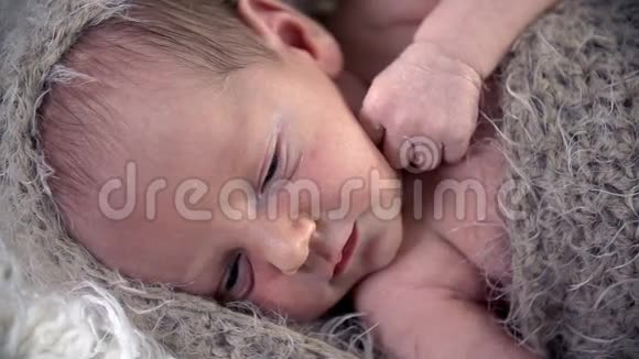 婴儿的眨眼被棕色的羊毛布覆盖视频的预览图