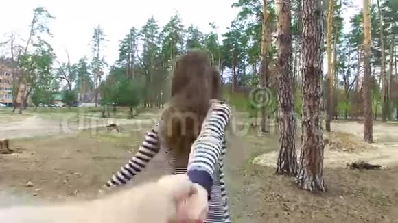 年轻女子牵着男人的手带他到户外的大自然中去视频的预览图